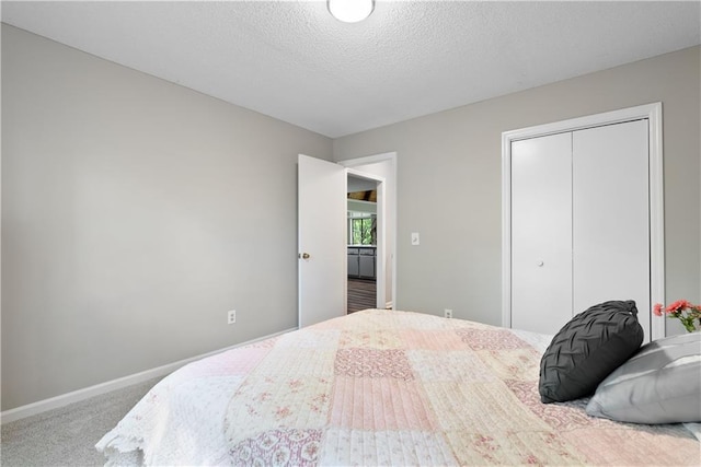 carpeted bedroom with a closet and a textured ceiling