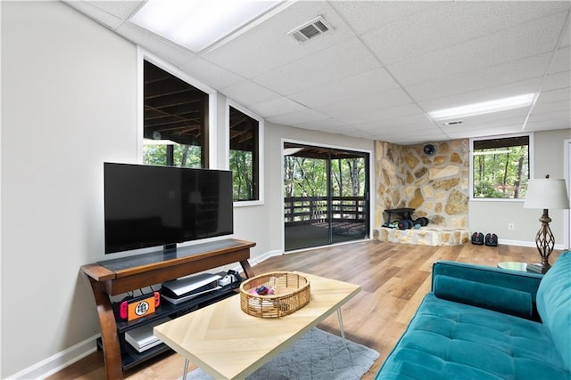 living room with hardwood / wood-style floors and a drop ceiling