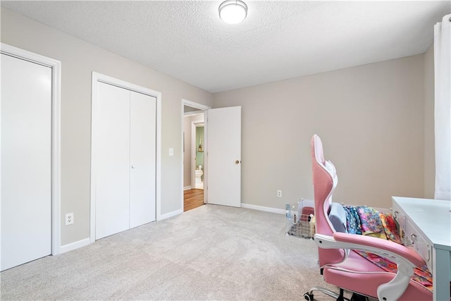 office with light colored carpet and a textured ceiling