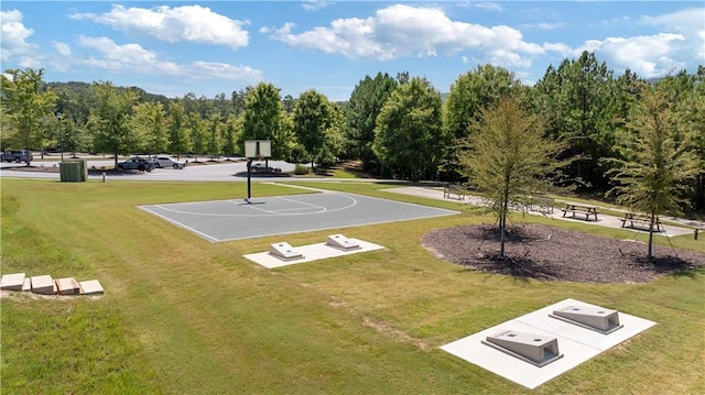 view of basketball court with a yard