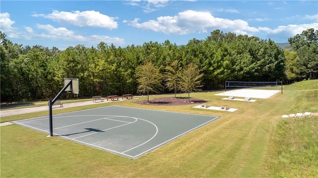 view of sport court featuring a lawn and volleyball court