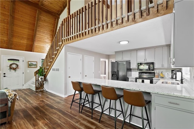 kitchen with sink, wood ceiling, a breakfast bar area, and black appliances