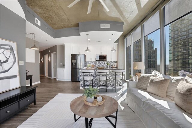 dining space featuring ceiling fan, a wall of windows, and light hardwood / wood-style flooring