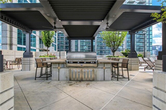 view of patio / terrace with area for grilling, ceiling fan, and grilling area