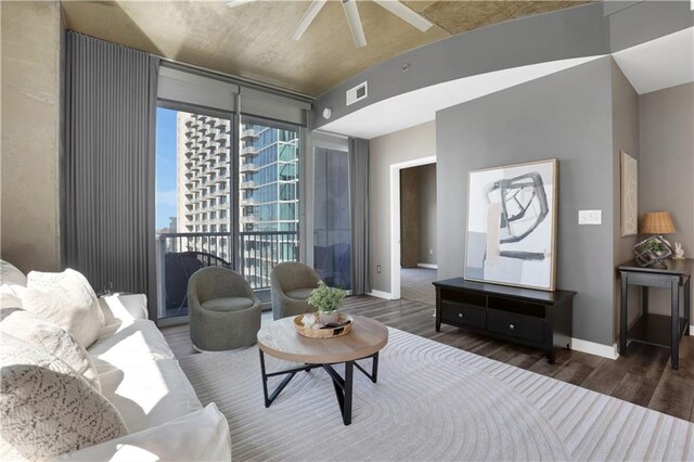 living room with ceiling fan, expansive windows, and light wood-type flooring