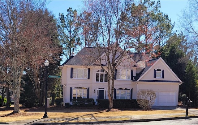 view of front of property featuring stucco siding, a garage, and driveway