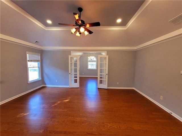 unfurnished room featuring visible vents, a tray ceiling, wood finished floors, and french doors