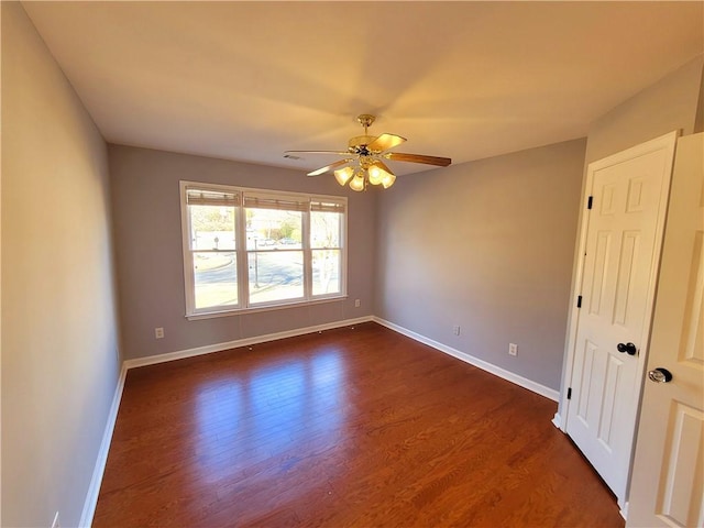 empty room featuring dark wood-style floors, ceiling fan, and baseboards