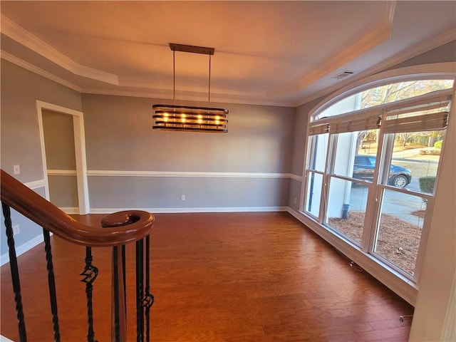 empty room with dark wood finished floors, visible vents, crown molding, and baseboards