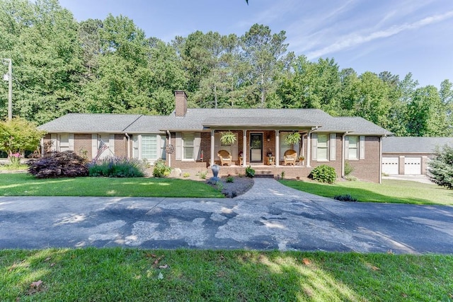 ranch-style home featuring a porch, a garage, and a front yard