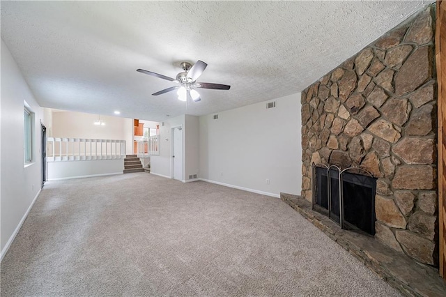 765 Martin Rd, Stone Mountain, GA 30088 - unfurnished living room featuring a textured ceiling, carpet floors, a stone fireplace, ceiling fan, and baseboards