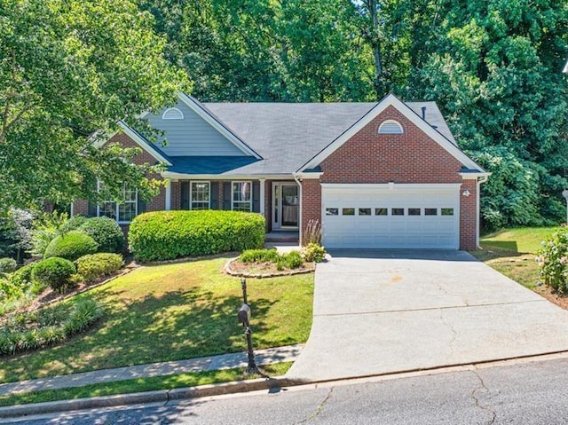 view of front of home featuring an attached garage, driveway, a front lawn, and brick siding