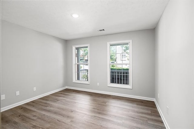 spare room featuring dark wood-style flooring, baseboards, a textured ceiling, and recessed lighting