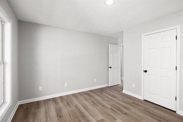 unfurnished bedroom featuring wood finished floors and baseboards