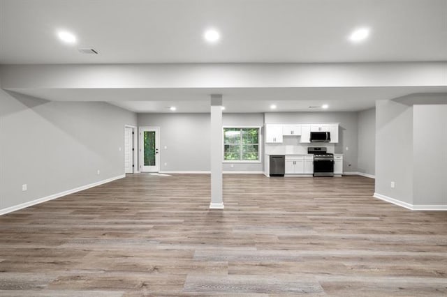 unfurnished living room featuring baseboards, light wood-style floors, and recessed lighting