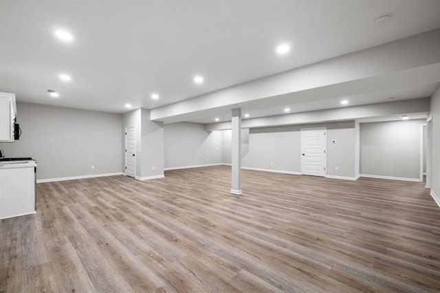 finished basement with recessed lighting, baseboards, and light wood-style floors