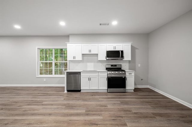 kitchen with stainless steel appliances, white cabinets, light countertops, baseboards, and recessed lighting