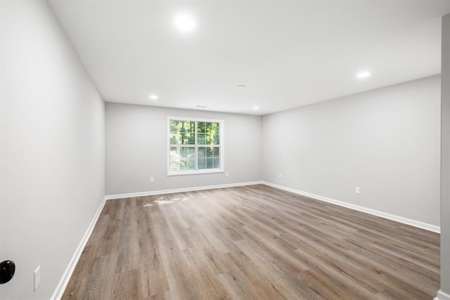 unfurnished room featuring wood finished floors, recessed lighting, and baseboards
