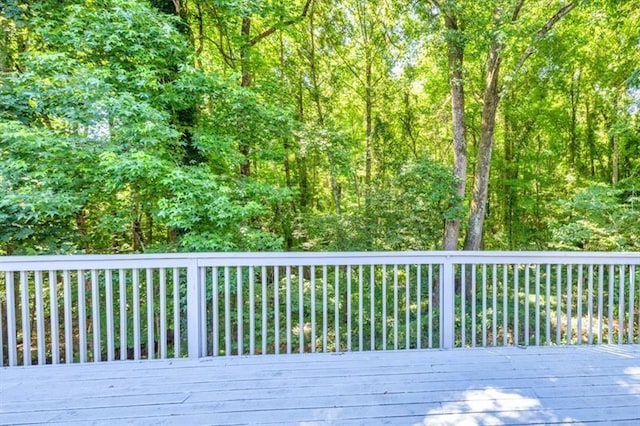 wooden terrace featuring a view of trees