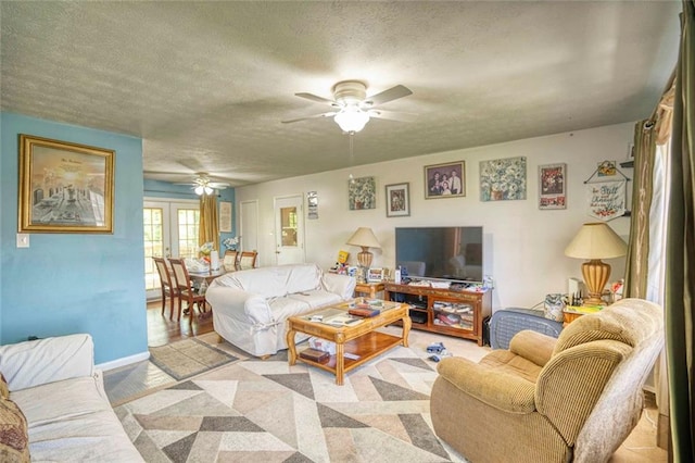 living room with ceiling fan, a textured ceiling, and french doors