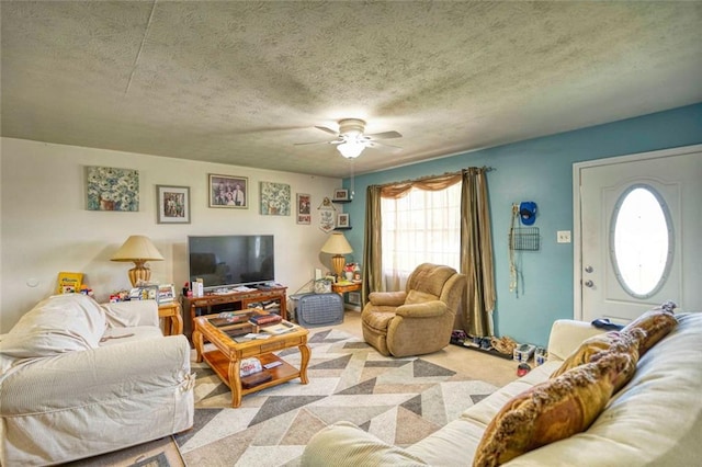 carpeted living room featuring ceiling fan and a textured ceiling