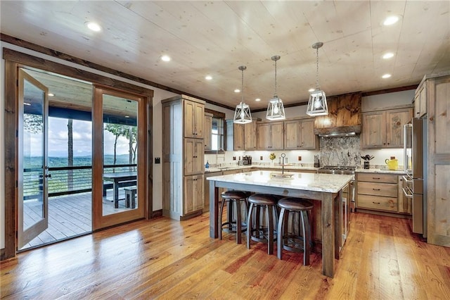 kitchen with premium range hood, a water view, pendant lighting, a large island, and light stone countertops