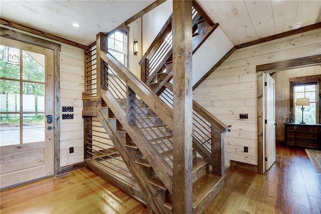 stairway with hardwood / wood-style floors and wood walls