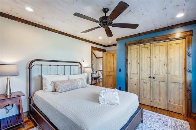 bedroom with crown molding, ceiling fan, hardwood / wood-style floors, and a closet