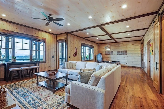 living room featuring coffered ceiling, wooden walls, ceiling fan, and light wood-type flooring