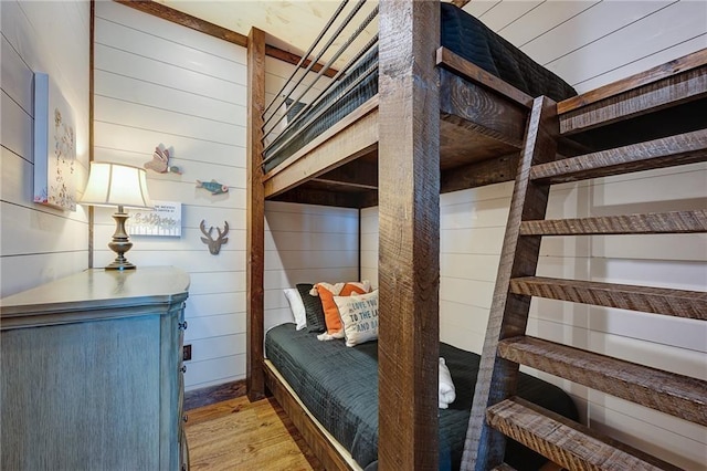 bedroom featuring wood walls and light wood-type flooring