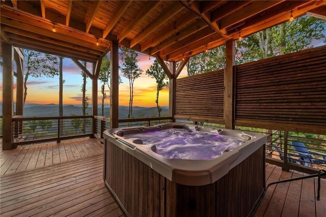 deck at dusk with a hot tub