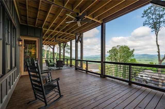 wooden deck featuring ceiling fan and a mountain view