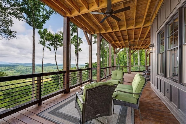 wooden deck with outdoor lounge area and ceiling fan