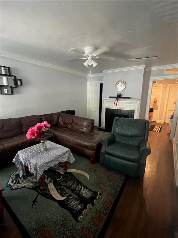 living room featuring crown molding, wood-type flooring, and ceiling fan