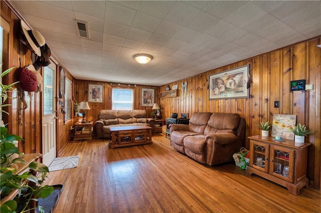 living room featuring wood walls and light hardwood / wood-style flooring