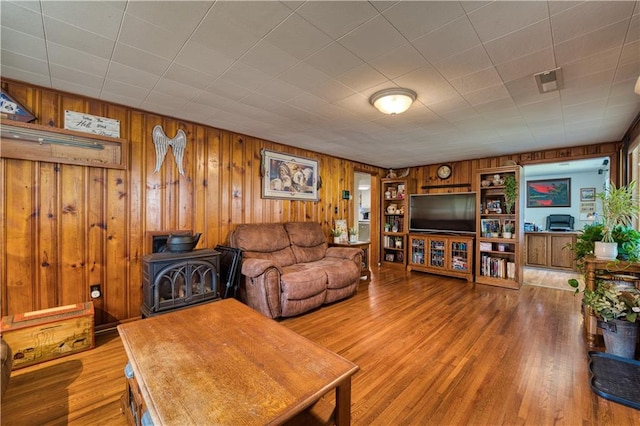 living room with light wood-type flooring and wooden walls