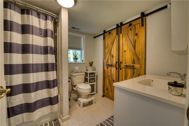 bathroom with a textured ceiling, vanity, walk in shower, tile patterned flooring, and toilet