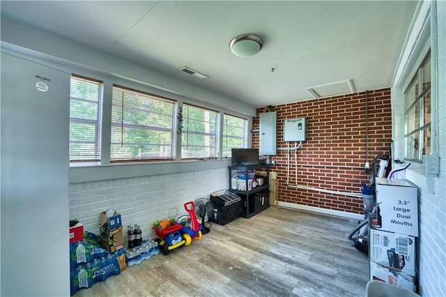 interior space with wood-type flooring and brick wall