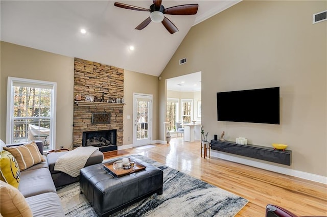 living room featuring ceiling fan, a fireplace, high vaulted ceiling, and hardwood / wood-style floors