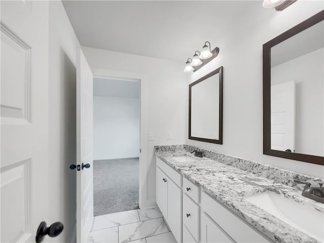 bathroom with double vanity, marble finish floor, and a sink