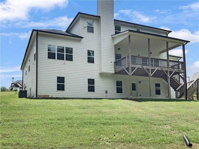 back of property featuring central AC, a lawn, a chimney, and stairs