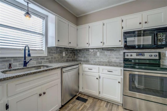 kitchen featuring light stone counters, appliances with stainless steel finishes, sink, and white cabinets