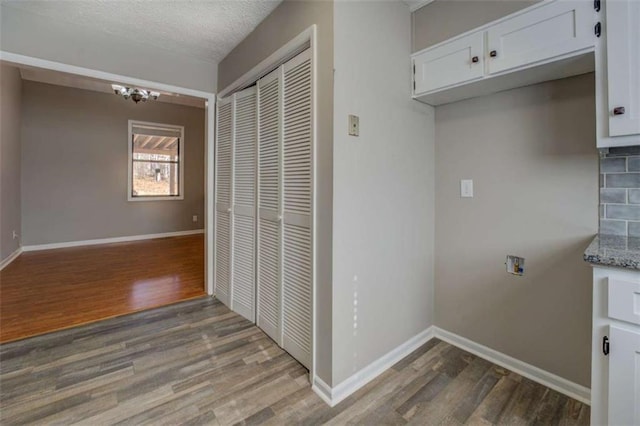 laundry area featuring washer hookup, hardwood / wood-style floors, and a textured ceiling