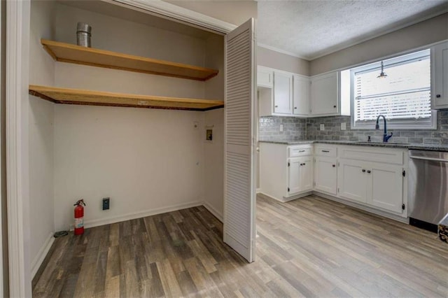 interior space featuring sink, hardwood / wood-style floors, hookup for a washing machine, ornamental molding, and a textured ceiling