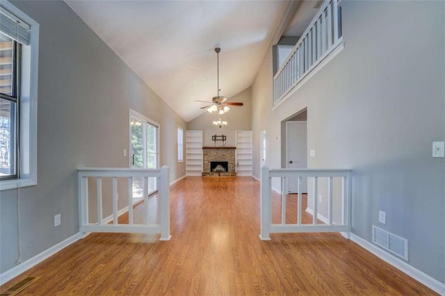 unfurnished living room featuring high vaulted ceiling, light hardwood / wood-style floors, and ceiling fan