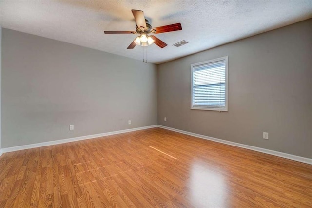 unfurnished room featuring ceiling fan, light hardwood / wood-style flooring, and a textured ceiling