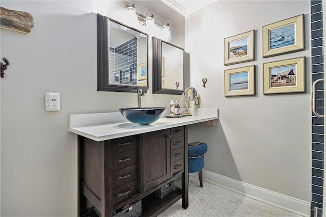 bathroom with crown molding, baseboards, and vanity