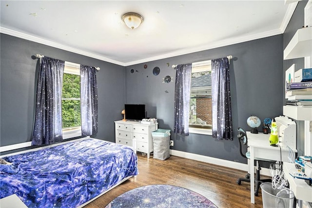 bedroom featuring crown molding, baseboards, and wood finished floors