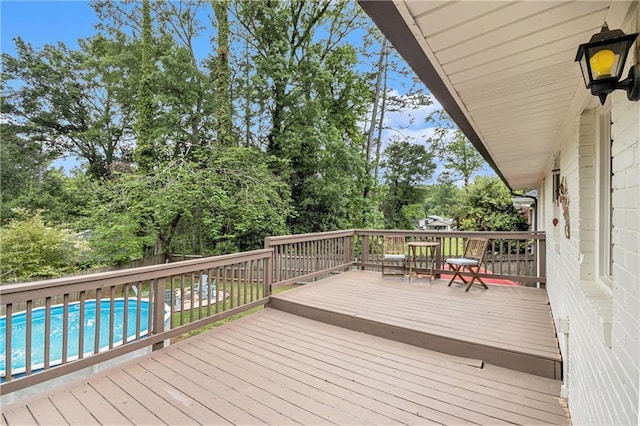 wooden deck featuring a fenced backyard and an outdoor pool