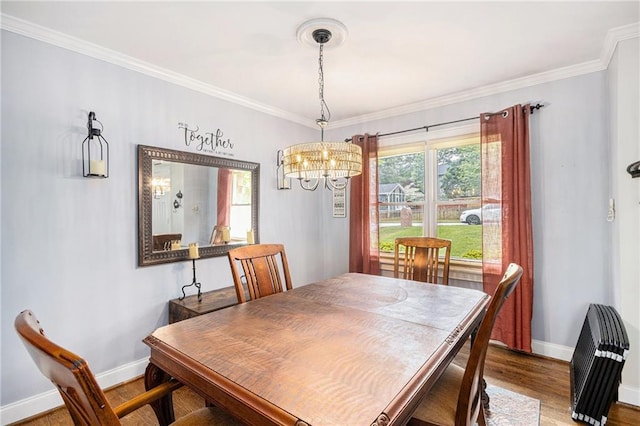 dining room with baseboards, a chandelier, ornamental molding, and wood finished floors